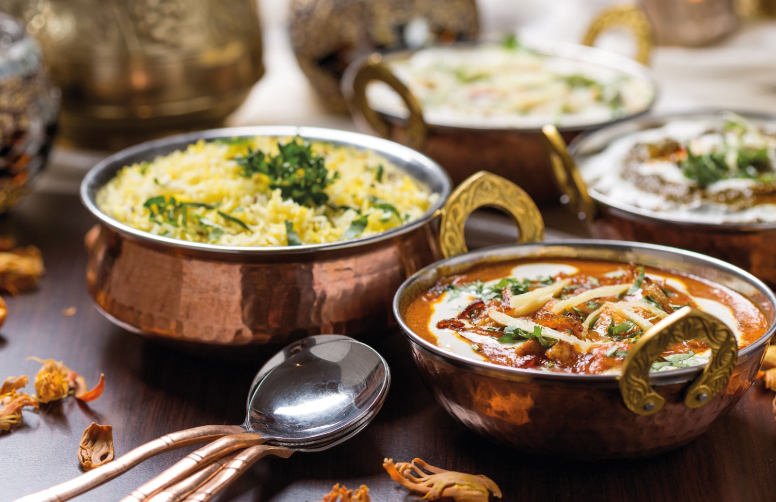 Metal bowls with various curries and rices in
